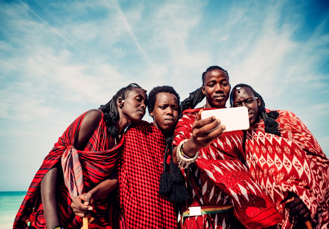 Group of four friends takes a selfie in red tribal clothing.