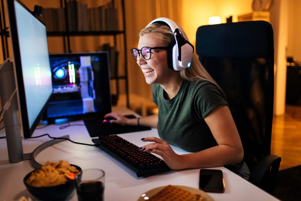 Woman laughs whilst using a computer.