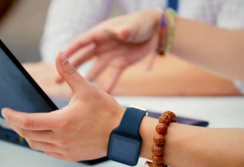 Hands gesturing in front of a laptop.