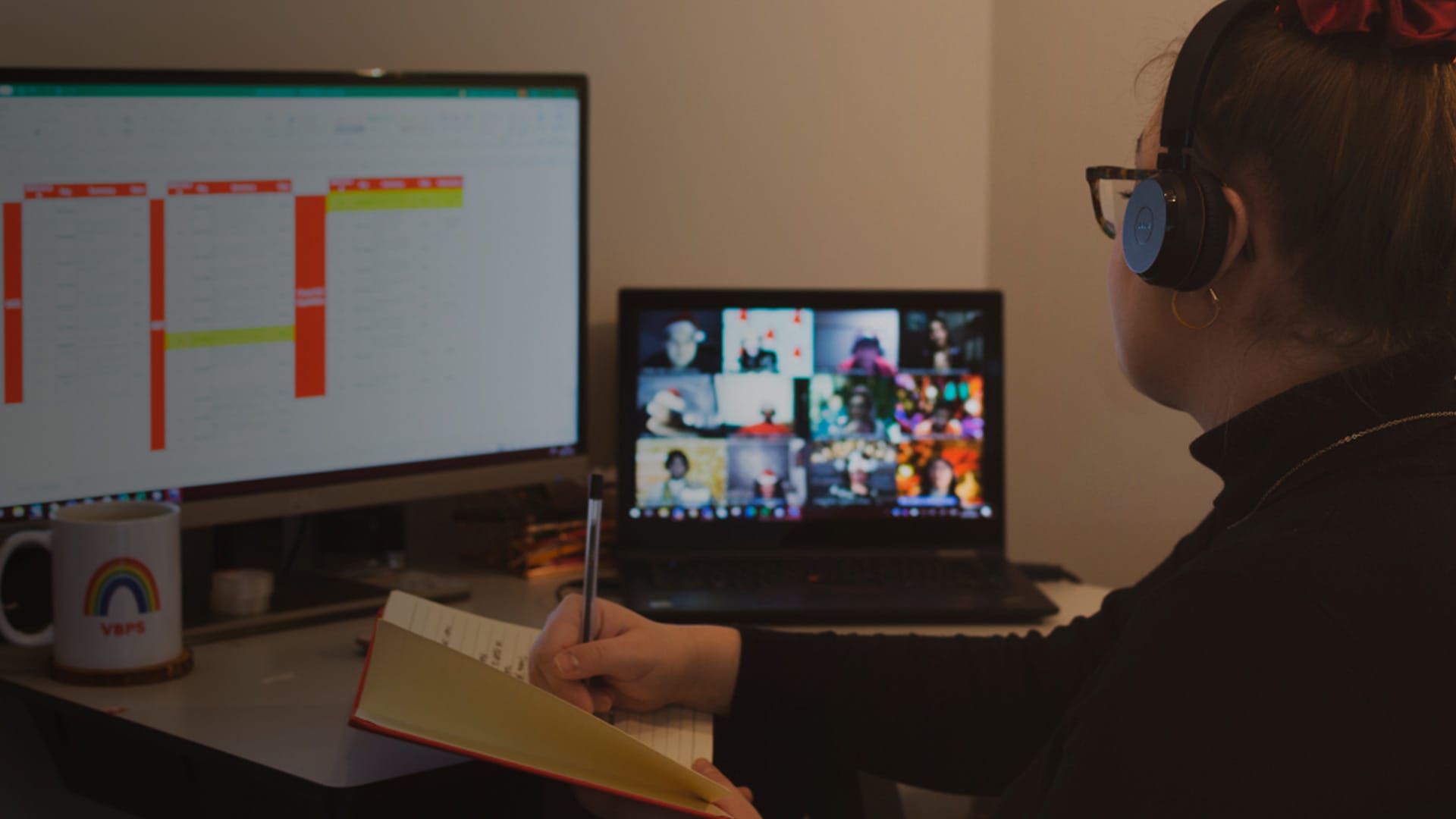 Young team member taking notes while on a Zoom call.